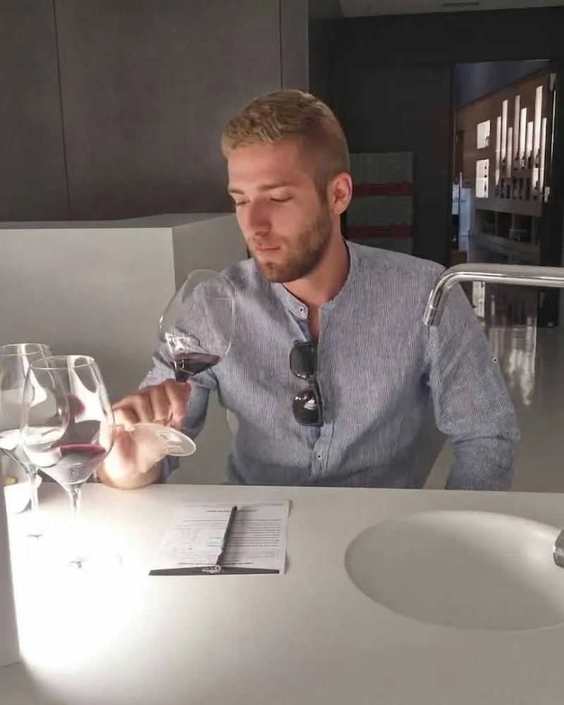 Víctor Sánchez catando una copa de vino tinto en una sala de catas